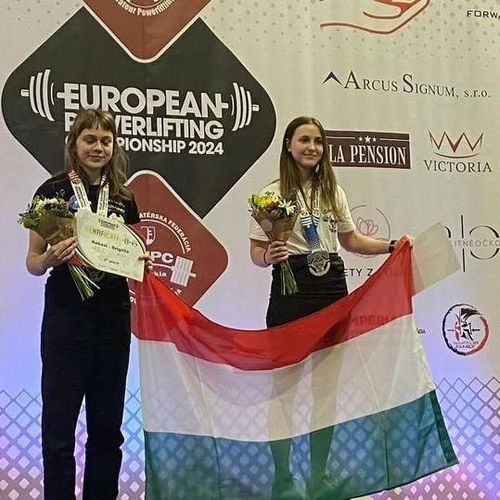 A képen két lány látható magyar zászlóval a kezükben